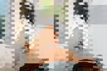 A medical professional performs an ultrasound on a pregnant person's belly in a clinic.